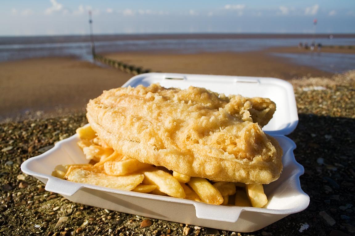 Traditional fish and chips served in a takeaway tray by the seaside